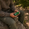 Person holding a green AirVape Legacy Core during an outdoor session