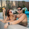 Couple holding a portable Dr. Dabber Ghost 2 wax vaporizer in a swimming pool