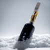 Black G Pen 510 OG battery with cartridge positioned upright in fresh snow