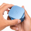 Blue Haze PAX Grinder held in both hands showing the smooth rotating lid